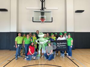 Group of people standing together and smiling for a picture in a gym